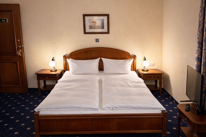 Doppelbett mit Holzkopfteil und zwei Nachttischen